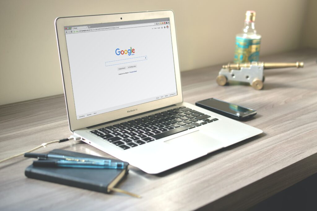 An image of a laptop on a desk with Google showing on the screen