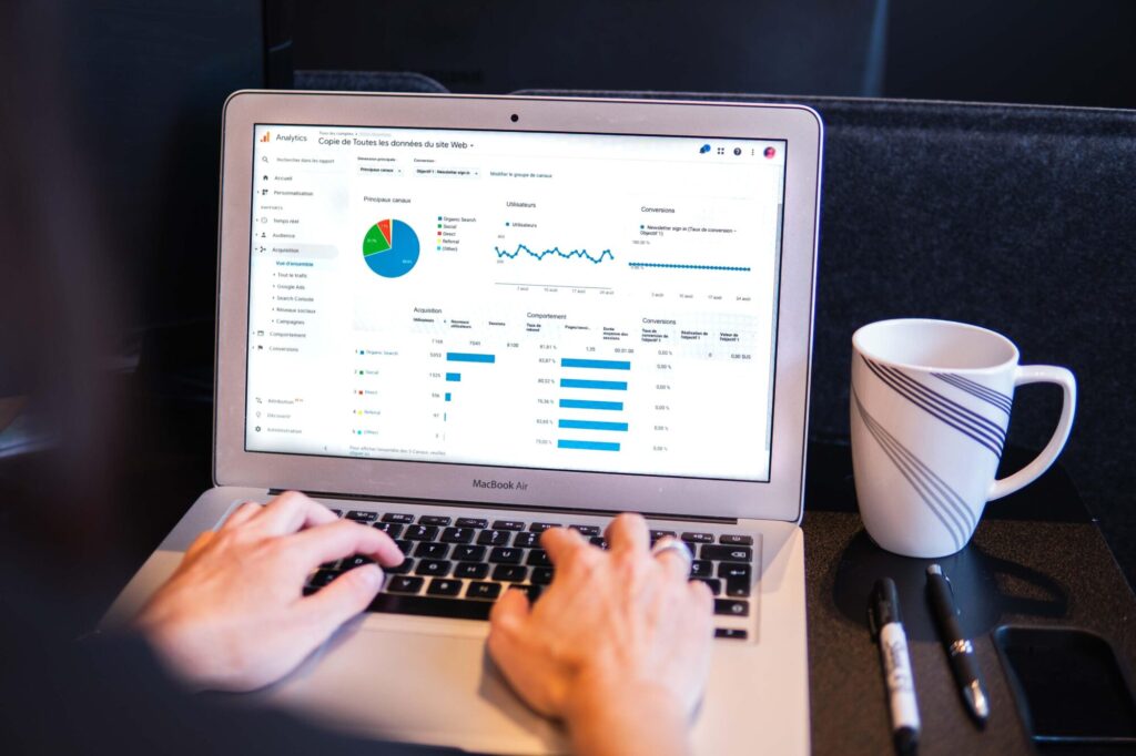 A computer on a desk showing google analytics charts.